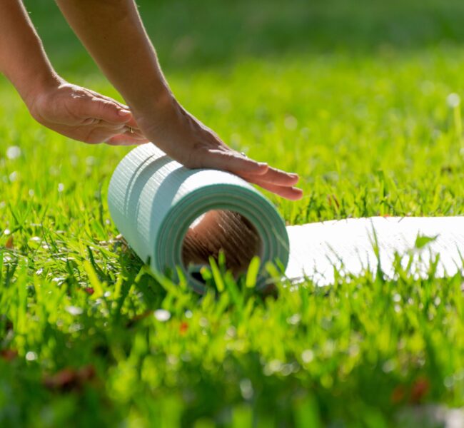 closeup-of-hands-rolling-yoga-mat-in-a-green-meado-2026-03-17-07-24-26-utc