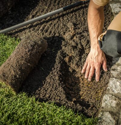 Underground Garden Fencing Underground Fencing and Grass Installation in a Garden. Caucasian Gardener. Agriculture Industry.